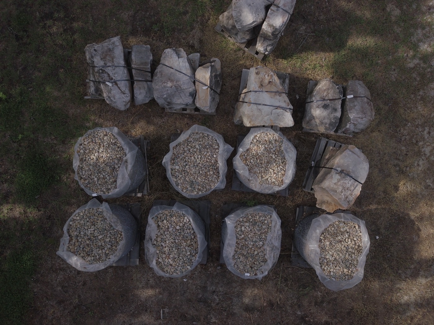 Pallets of boulders and pallet baskets of river rock in the yard